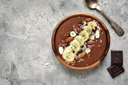 Chocolate banana smoothie bowl with nuts and chia seeds.Top view