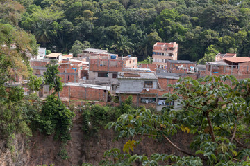Fototapeta na wymiar Favela invading the vegetation area inside the city