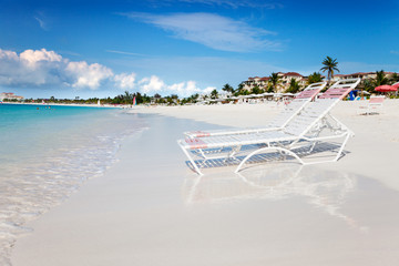 Beach chaises at water's edge on the soft white sands of Grace Bay Beach, Turks & Caicos