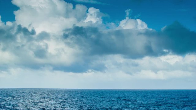 A Moving Ocean Scape seen from a Sea Going Vessel with Majestic Clouds and Blue Water