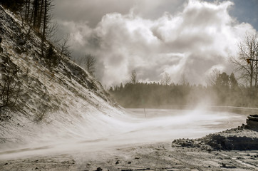 Snow Blowing Across a Road with amazing clouds in the sky