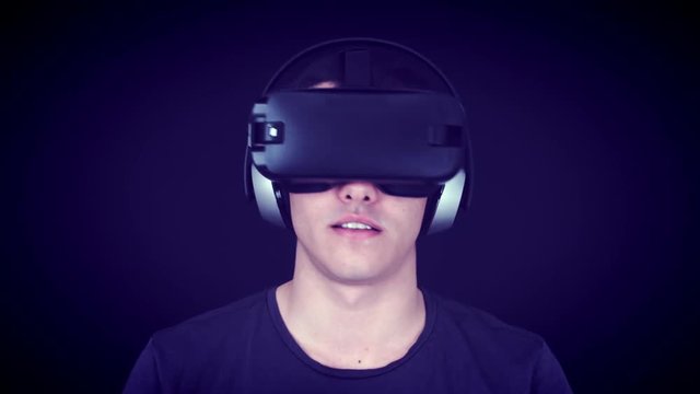 Young man wearing VR Headset and playing virtual reality games. Captured with Blackmagic Production Camera 4K with RAW settings.