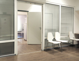 Hospital waiting room with chairs and open door