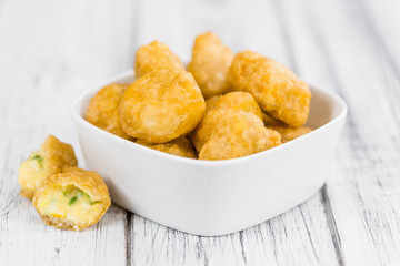 Chili Cheese Nuggets (selective focus) on vintage wooden backgro