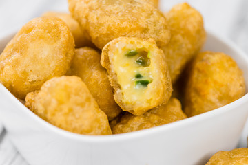 Chili Cheese Nuggets (selective focus) on vintage wooden backgro