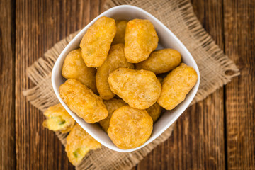 Wooden table with Chili Cheese Nuggets (selective focus)