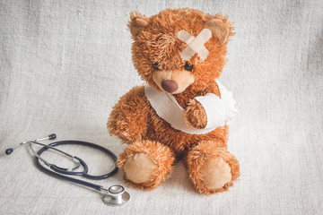 concept teddy bear childhood diseases at textile background