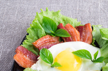 Egg yolk, fried bacon, herbs and lettuce