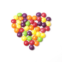 Fototapeta na wymiar Heart of colorful candies on white background