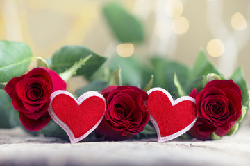 Red roses with two hearts on textured wood for Valentine's day