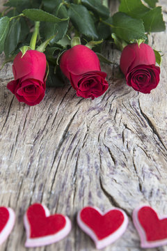 Red roses with hearts on textured wood for valentine's day