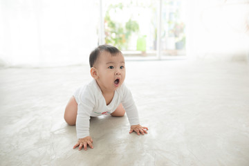 Fototapeta premium Little pretty baby girl crawling on the floor at home