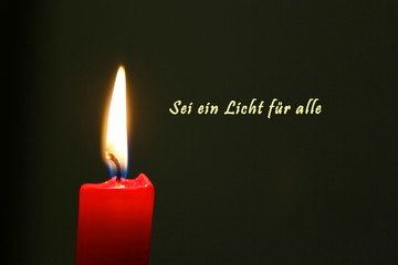 Rote Kerze mit Flamme und dunklem Hintergrund mit deutschem Text
