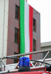 blue siren of the fire truck and the huge Italian flag