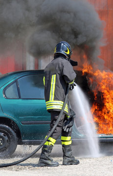 fireman extinguishes the fire of a car with foam