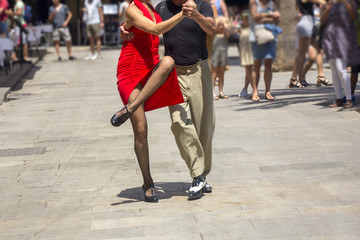 Street dancers performing tango in the street among the people