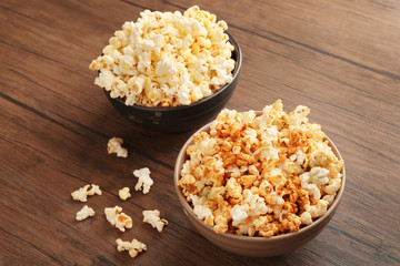 Obraz na płótnie Canvas Popcorn in bowls on wooden background