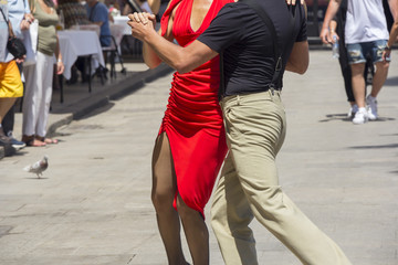 Street dancers performing tango in the street among the people
