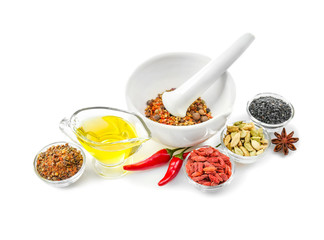 Composition with different spices and mortar on white background