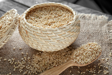 Wicker bowl of brown short grain rice on sackcloth closeup