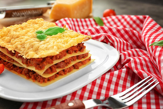Plate with tasty lasagna on napkin. Closeup