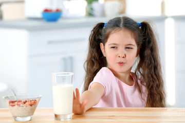 Cute little girl refusing to drink milk