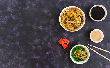 Udon noodles with seafood on dark background. Top view.