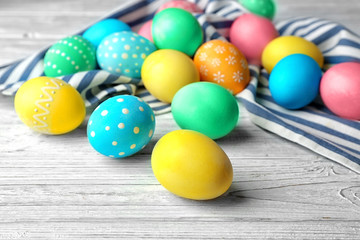 Fototapeta na wymiar Colorful Easter eggs and napkin on wooden table
