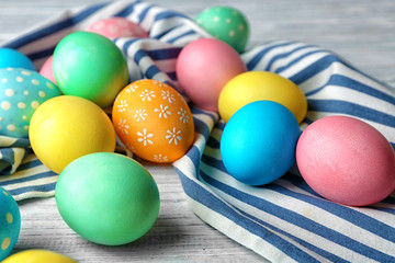 Fototapeta na wymiar Colorful Easter eggs and napkin on wooden table, closeup