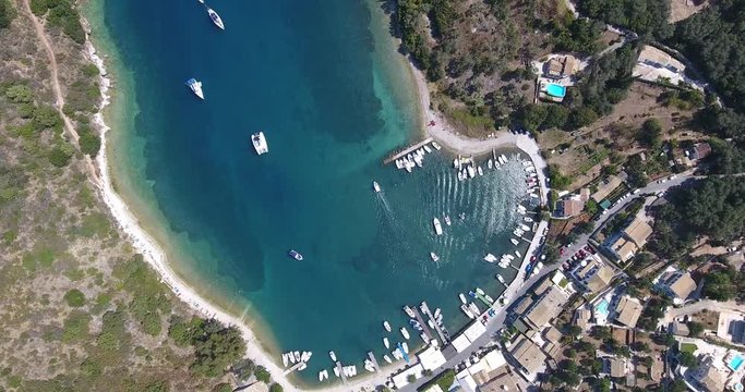 Corfu island bay with boats and clear blue waters. View from above from a drone.