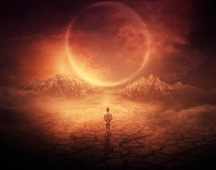 Surreal background as a young boy walks on another planet with dry and cracked ground, following a...