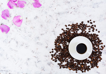 Coffee cup, coffee beans and rose petals on white background. Top view. Flat lay
