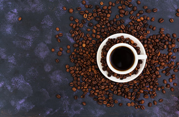 Obraz na płótnie Canvas Coffee cup and coffee beans on dark background. Top view. Flat lay