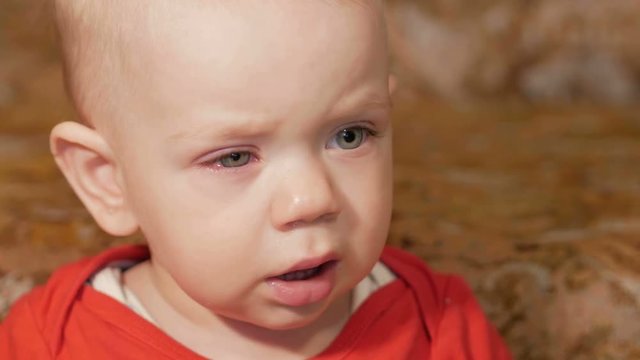 A beautiful baby with allergies. Red swollen eyes. The boy was crying and struggling with the disease. Kid 1 year. Close-up