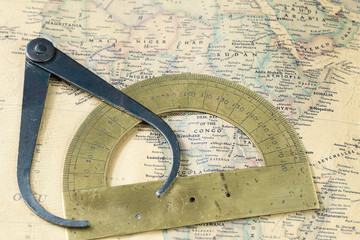 the old measuring tool and protractor on vintage map, macro background, compasses