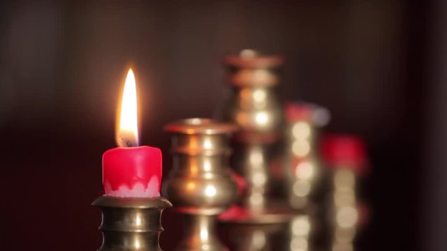 Color footage of a candle in a candlestick, fading out. 