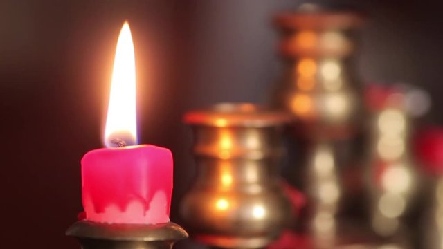 Color footage of a candle in a candlestick, put out with a tool. 
