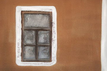 Old house window on colorful wall background.