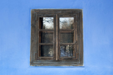 Old house window on colorful wall background.