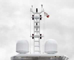 Close up view of satellite domes on top of a super yacht over cloudy sky background