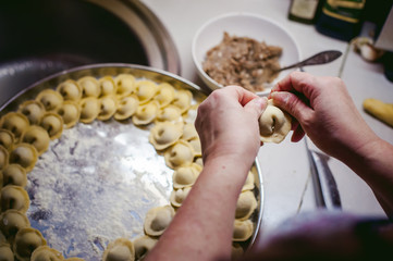 hand modeling dumplings at home in the kitchen.