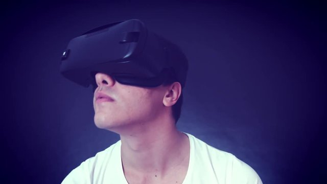 Young man wearing VR Headset and experiencing virtual reality. Captured with Blackmagic Production Camera 4K with RAW settings.