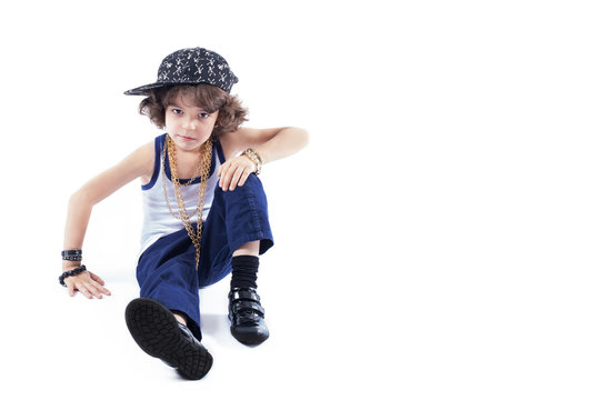 Little curly rapper sitting on the floor and looking into the camera. White background.