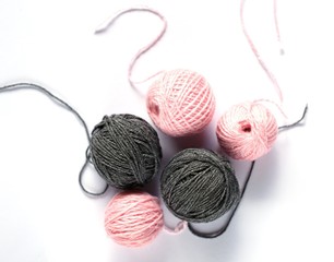 gray and pink balls of yarn on a white background