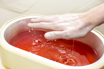 Process paraffin treatment of female hands in beauty salon
