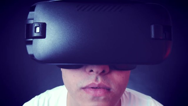 Young man wearing VR Headset and experiencing virtual reality. Captured with Blackmagic Production Camera 4K with RAW settings.