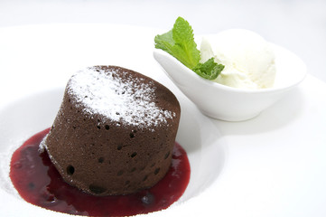 A piece of cream cake decorated with chocolate and mint