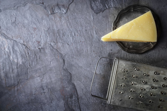 Cheese and grater on the stone background top view