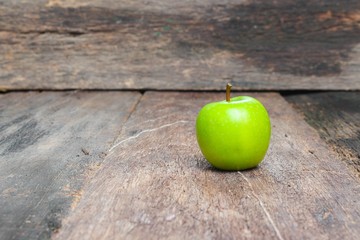 Green apple on wooden table  background