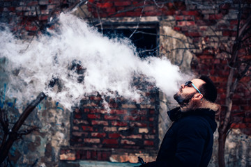 Man with beard vape electronic cigarette outdoor